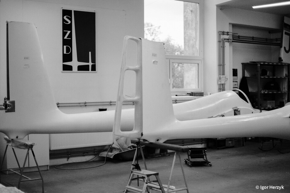 Segelflugzeuge in Werkstatt oder Ausstellungshalle, schwarz-weiß Aufnahme.